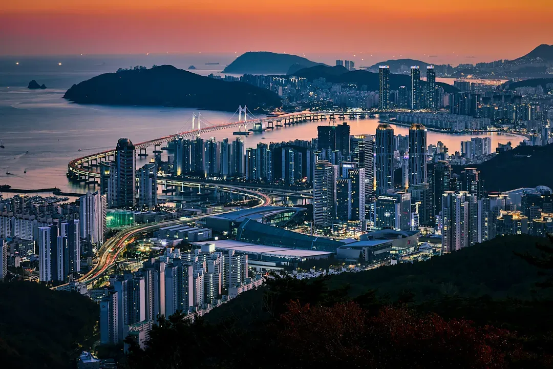 Gwangandaegyo Bridge and Busan skyline glowing at autumn dusk