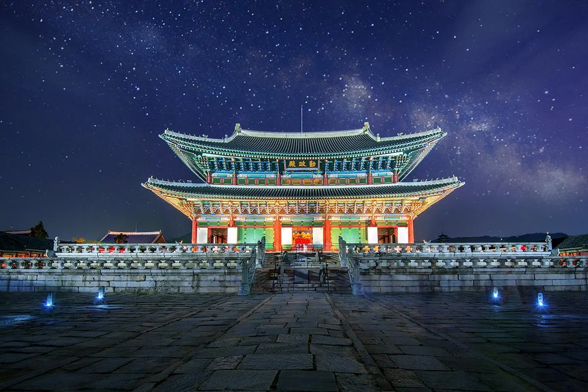 Gyeongbokgung Palace Geunjeongjeon Hall illuminated under a starry night sky in Seoul