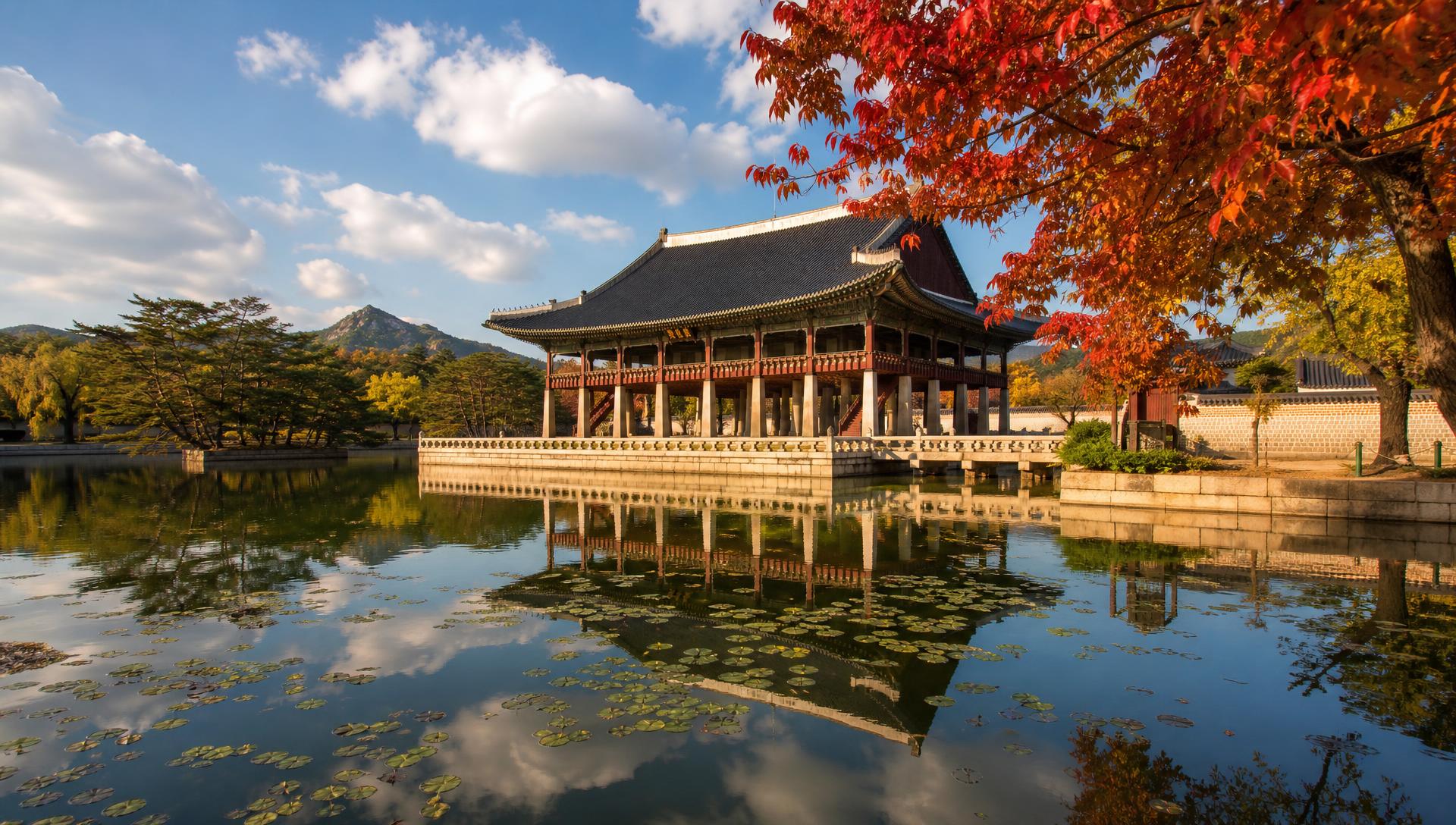Gyeonghoeru Pavilion reflected in a calm lotus pond under a bright autumn sky at Gyeongbokgung Palace